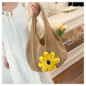 Detail of hand-woven beige mesh tote bag featuring a large yellow crochet sunflower