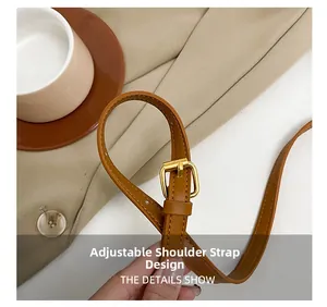 Detail of adjustable brown leather shoulder strap with gold-tone buckle for handbag