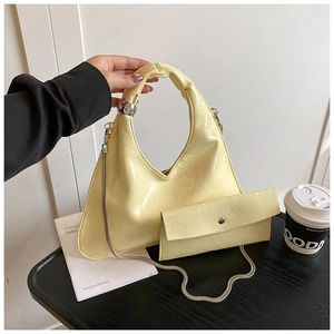 Borsa a mezzaluna giallo pallido minimalista con trama plissettata e dettaglio sfera d'argento