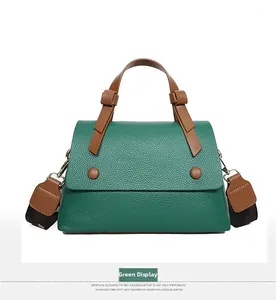 Macro detail of green lychee leather texture and contrast brown handle on handbag