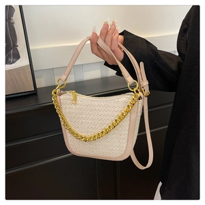 Detail of woven fabric shoulder bag with gold chain and smooth pink leather trim