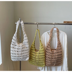 Detail of hand-woven hollow knit tote bags in white, green, and camel with drawstring liners