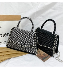 Detailed close-up of two black rhinestone handbags with silver chain straps and top handles