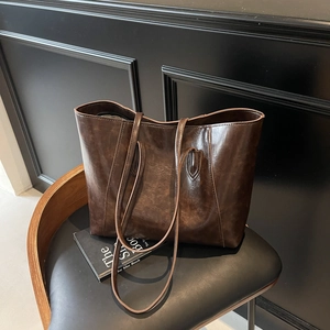 Retro dark brown large capacity faux leather tote bag on a modern black chair