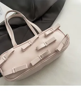 Detail of pink bow handbag featuring soft PU leather texture and six 3D ribbon ornaments