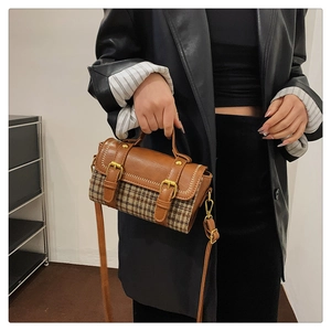 Detail of houndstock pattern stitching and leather handle on a vintage handbag