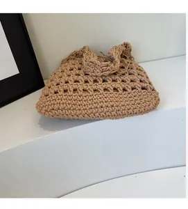 Detail of handmade woven hollow shoulder bag in earthy tones with dense bottom weave