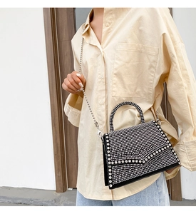 Close-up of black rhinestone chain bag featuring sparkling crystals and silver ball chain