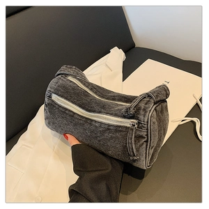 Détail du sac baril en denim délavé gris avec deux fermetures éclair argentées chics