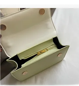 Détail de l'intérieur en cuir vert clair avec fermeture éclair dorée et boucles magnétiques