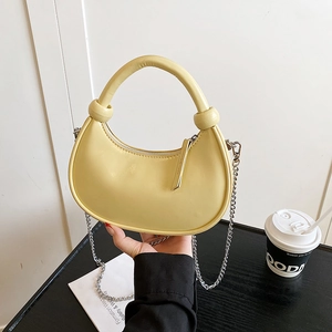 Pale yellow crescent leather handbag with silver chain strap and knot handle detail