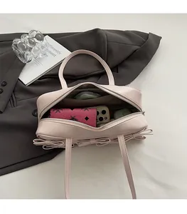 Detailed interior of a pink bow handbag showing compartments and storage capacity