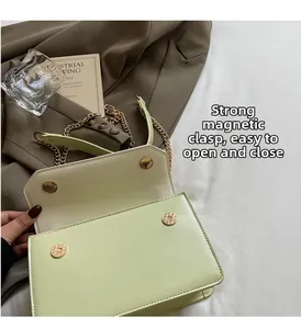 Détail du sac en cuir vert clair montrant les fermoirs magnétiques et la chaîne
