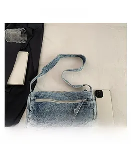 Détail d'un sac baril en denim vintage avec fermetures éclair argentées et bandoulière