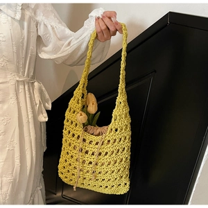 Detail of hand-woven hollow knit tote bag in bright yellow with drawstring inner pouch