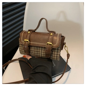 Detail view of the brown leather and plaid fabric patchwork on the retro handbag