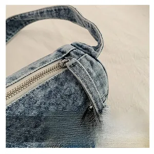 Détail du tissu denim bleu délavé vintage avec une fermeture éclair en métal argenté lisse