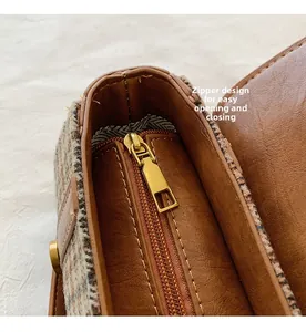 Detail of internal zipper pocket and smooth leather lining inside the houndstooth bag