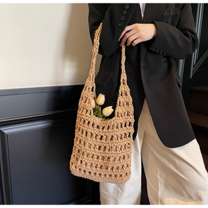Close-up of beige hollow-out woven tote bag with tulip flowers and premium knit texture