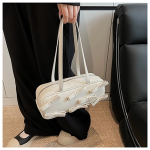 Detailed shot of a white glossy handbag featuring five 3D bows and dual slim handles