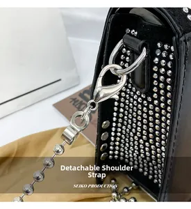 Detail of black leather bag with silver rivets and detachable metal chain strap