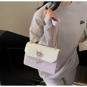 Détail du fermoir chat en métal doré avec gemmes violettes sur le sac à bandoulière