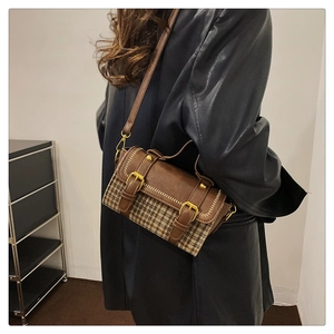 Detail of vintage crossbody bag showing brown leather texture and houndstooth pattern fabric