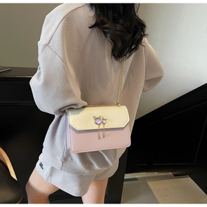 Détail d'un sac à chaîne chic avec fermoir en métal chat et blocs de couleurs pastel doux