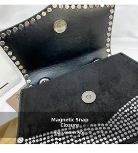 Detailed close-up of the magnetic buckle closure and silver stud accents on a black bag