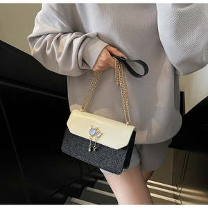 Détail du sac à chaîne avec ornement chat en gemme et pompon à franges métal