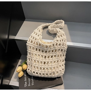 Detail of white crochet tote bag showing woven texture and drawstring inner pouch