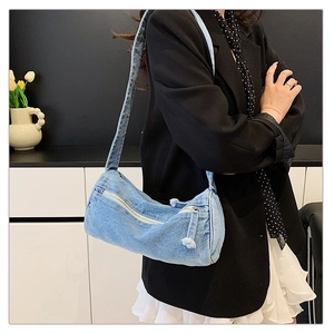 Détail du sac cylindre en jean bleu clair au look rétro avec décorations de fermeture