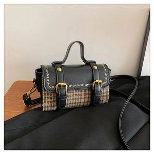 Detail of retro houndstooth pattern and leather stitching on the lady handbag