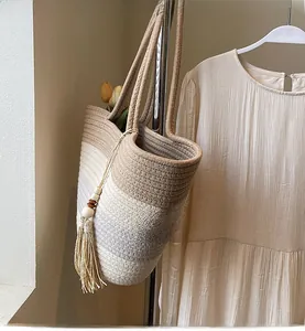 Macro detail of hand-woven straw tote with elegant side tassels and wood bead accents