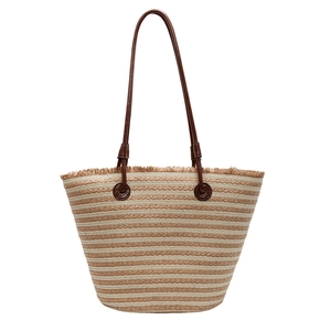 Fashionable striped woven tote bag with brown leather handles and fringe trim for summer beach