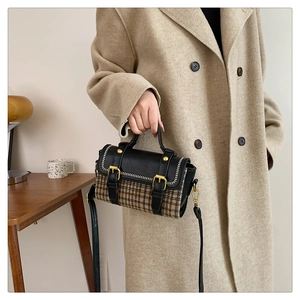 Detail view of houndstooth plaid crossbody bag with leather trim and gold hardware details