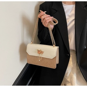 Détail des paillettes avec ornement chat en métal et chaîne dorée sur le sac à main