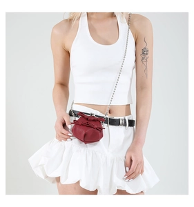 Mini dark red leather crossbody bag with bow and metal ball chain shown on model