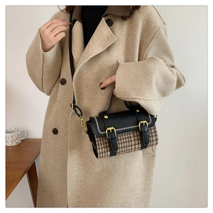 Close-up of vintage plaid handbag styled with an oatmeal cashmere coat for autumn