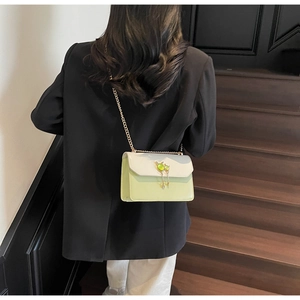 Détail du sac bandoulière blanc et vert avec chaîne dorée et ornements en pierre