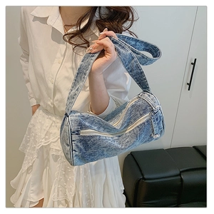 Vue détaillée du sac en jean vintage avec bandoulière large et fermeture éclair argent