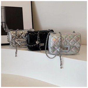 Trois sacs matelassés à chaîne en noir brillant, argent et holographique sur présentoir blanc