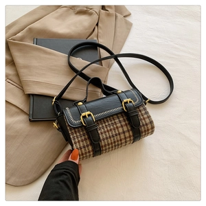 Detailed top view of plaid handbag with leather trim and gold hardware accessories