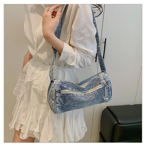 Mannequin portant un sac cylindre en jean bleu délavé vintage avec fermeture éclair coeur