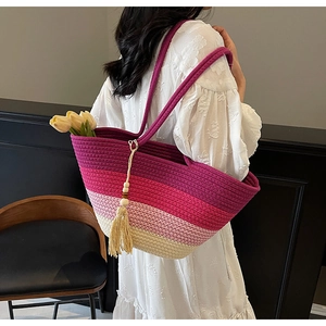 Detail of a colorful gradient straw tote bag with beaded tassels and a floral tulip accent