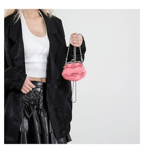 Detail of pink bow handbag featuring vintage silver clasp and metallic bead chain