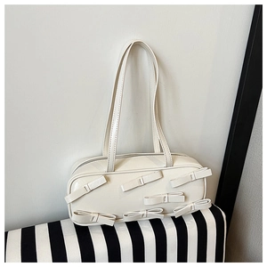 Detail of cream glossy shoulder bag featuring six 3D bow accents and slim double straps