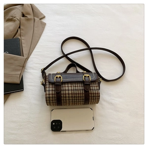 Miniature houndstooth cylinder bag with brown leather accents and gold buckle details
