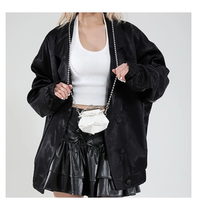 Detail of white mini bow bag with silver ball chain and retro metal clasp closure