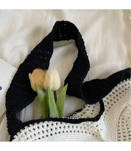 Detail of contrast stitch knitting on shoulder bag with long black strap and white crochet